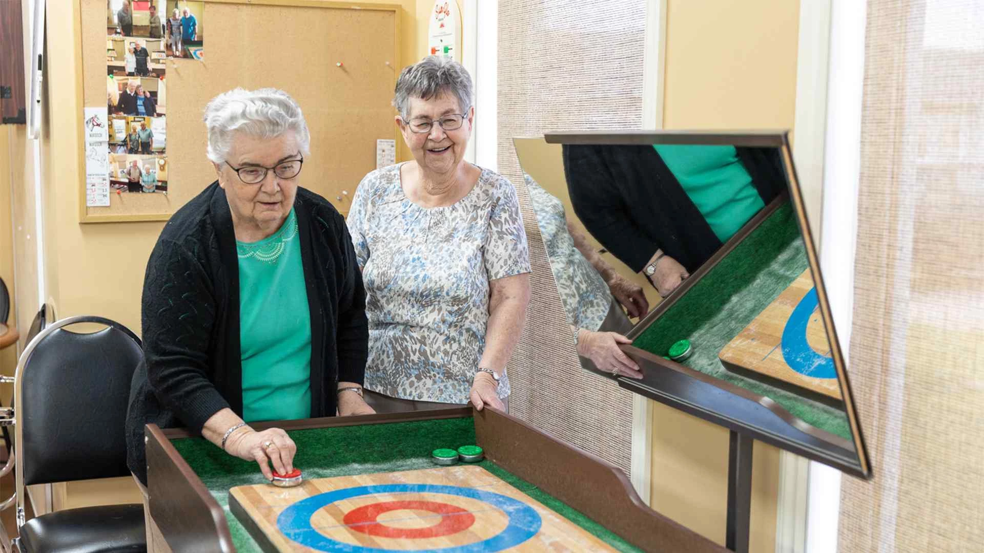 Two elderly women playing indoor games at CV