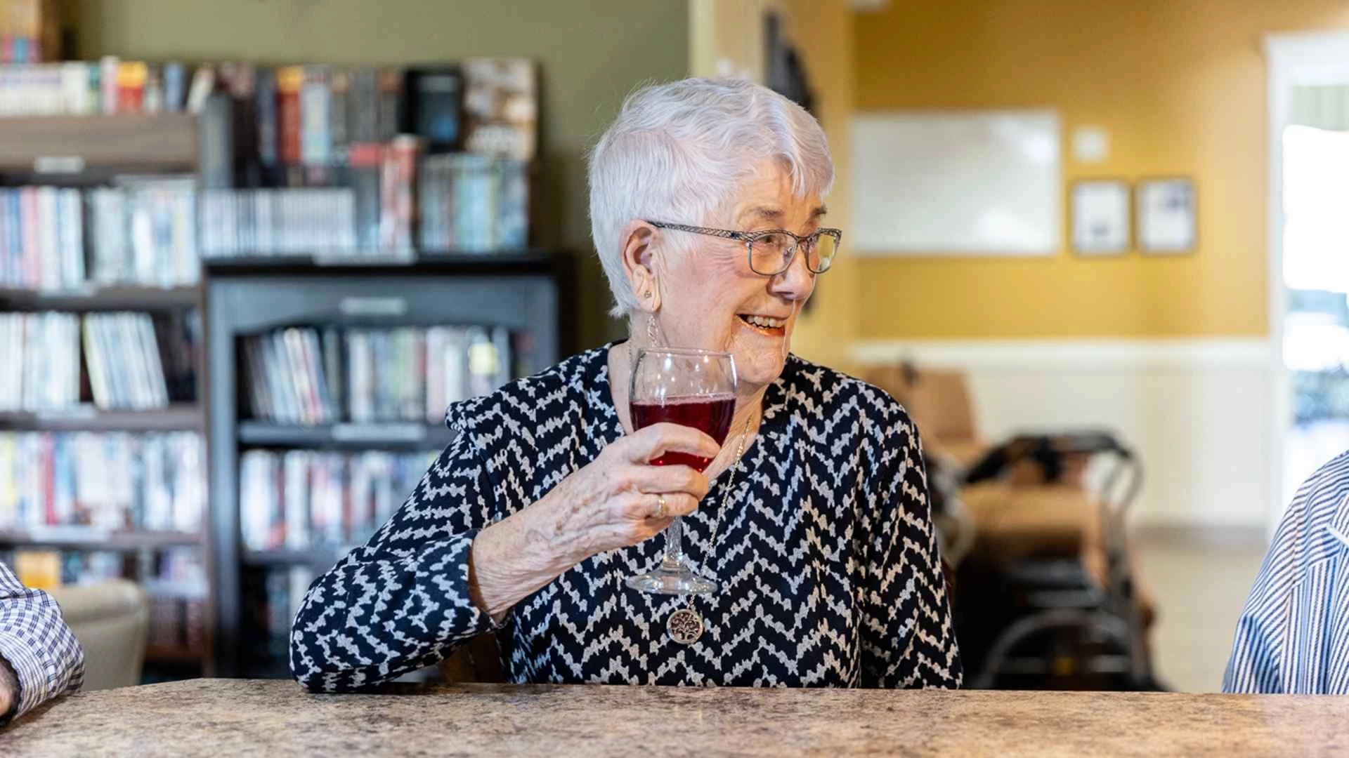 An elderly woman enjoying wine
